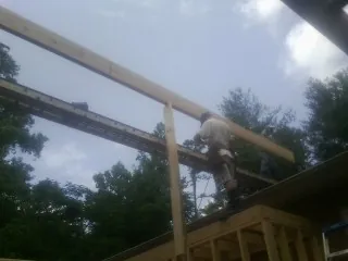 Carpenter setting a ridge beam over a new addition frame — Ice Dam Removal by Roofing Brothers in Dry Branch