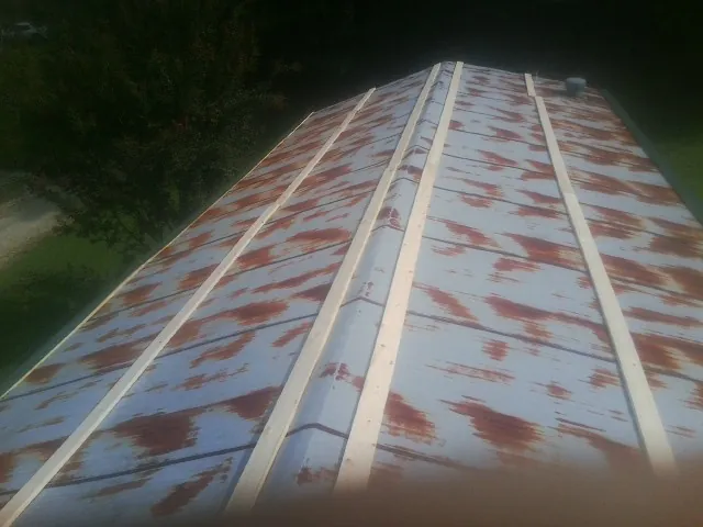 Rusted metal roof panels with new wood purlins before replacement — Storm Damage Roof Repair in Dry Branch by Roofing Brothers