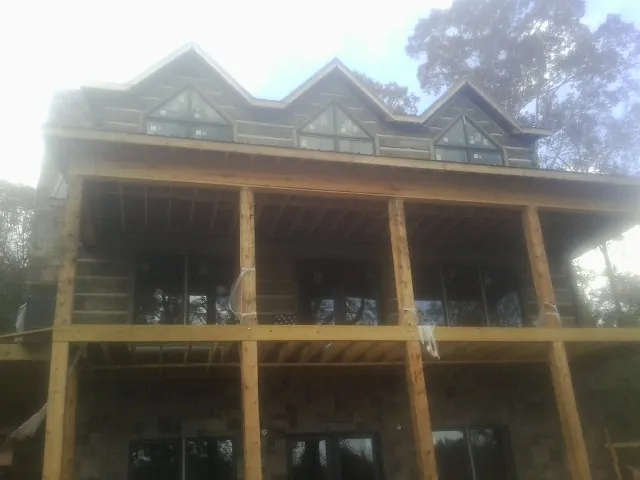 Dormers and porch framing on a large log home under construction — Roof Coating work by our crew in Dry Branch