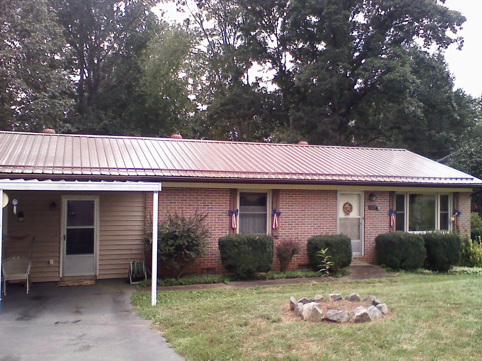 Bronze metal roof and carport on a brick ranch home — Roof Repair work by our crew in Dry Branch