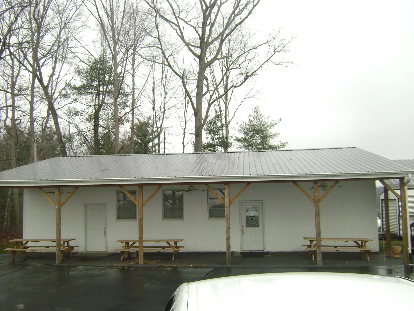 Gray metal roof over a block building with a timber post porch in Dry Branch